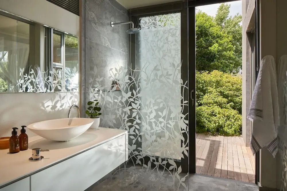 Modernes Badezimmer mit Glasdusche und Blick ins Grüne