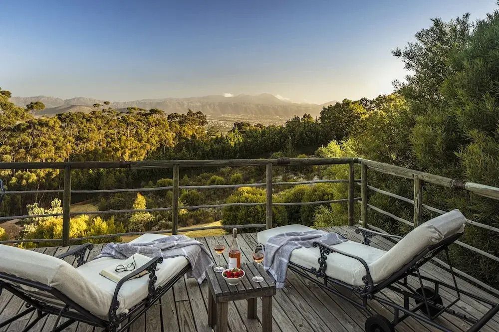 Holzterrasse mit Liegestühlen und Panoramablick auf die Landschaft