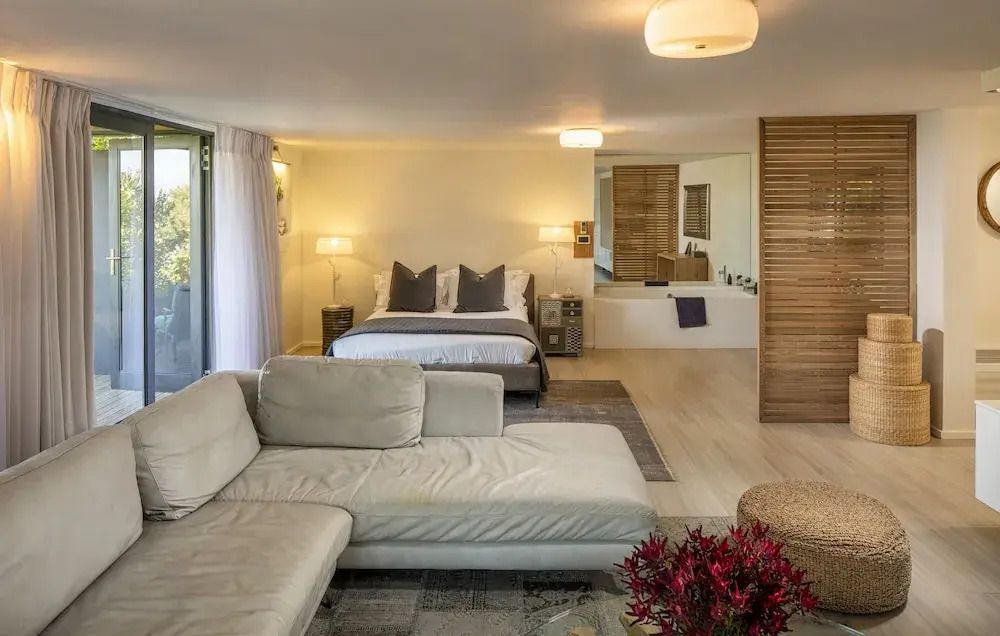 Offenes Schlafzimmer mit eleganter Sitzecke und Holzdetails