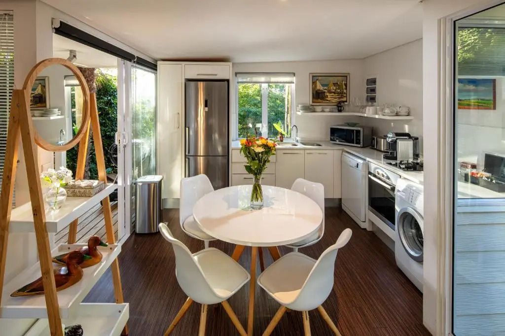 Moderne Küche im Bungalow mit Esstisch und großen Fenstern mit Gartenblick