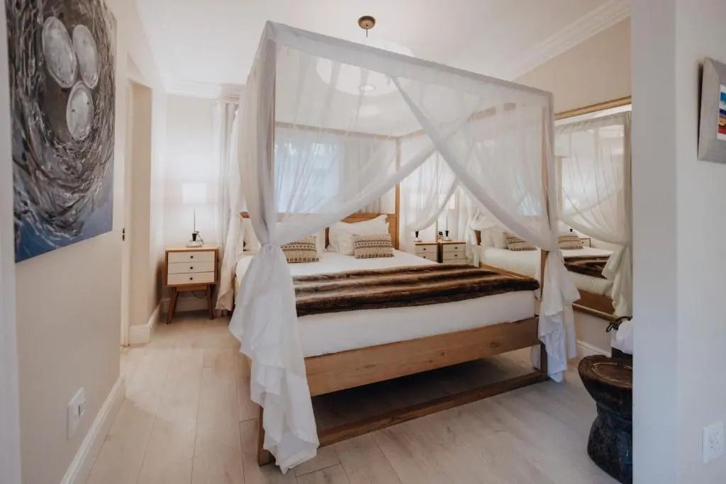 Helles Schlafzimmer mit Himmelbett und geschmackvoller Dekoration