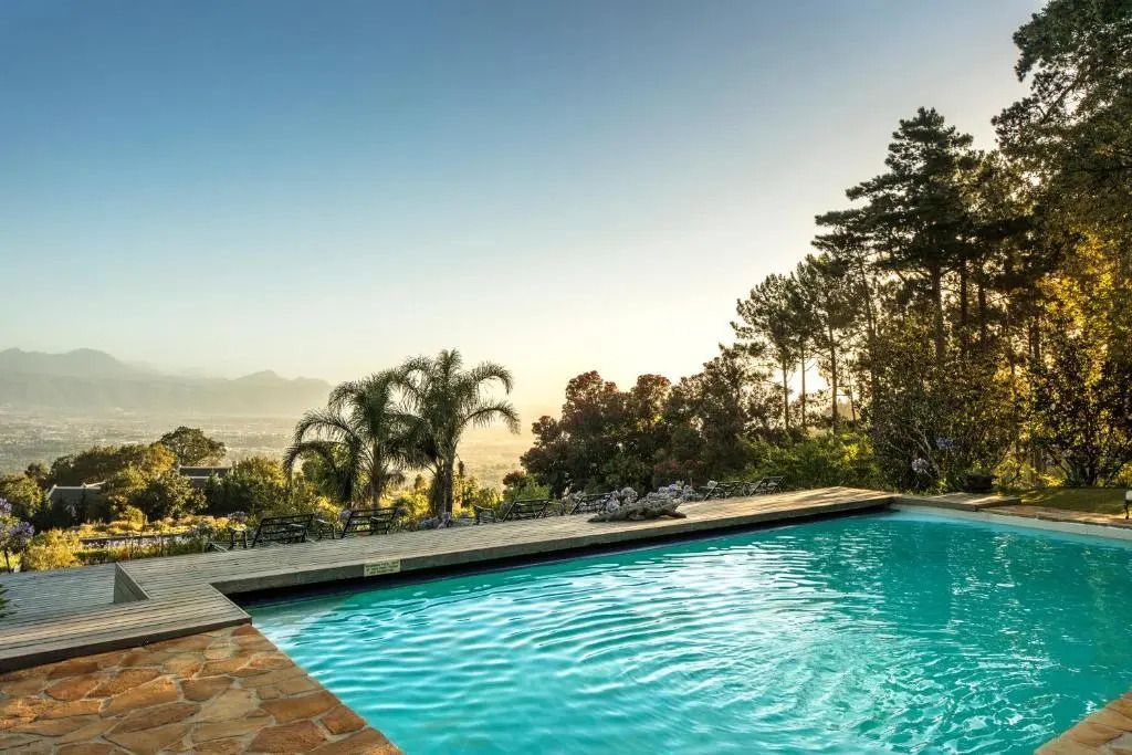 Pool mit Ausblick auf die umliegende Landschaft und Palmen