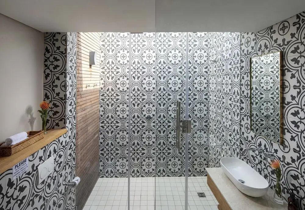 Modernes Badezimmer mit dekorativen Fliesen und Glasdusche