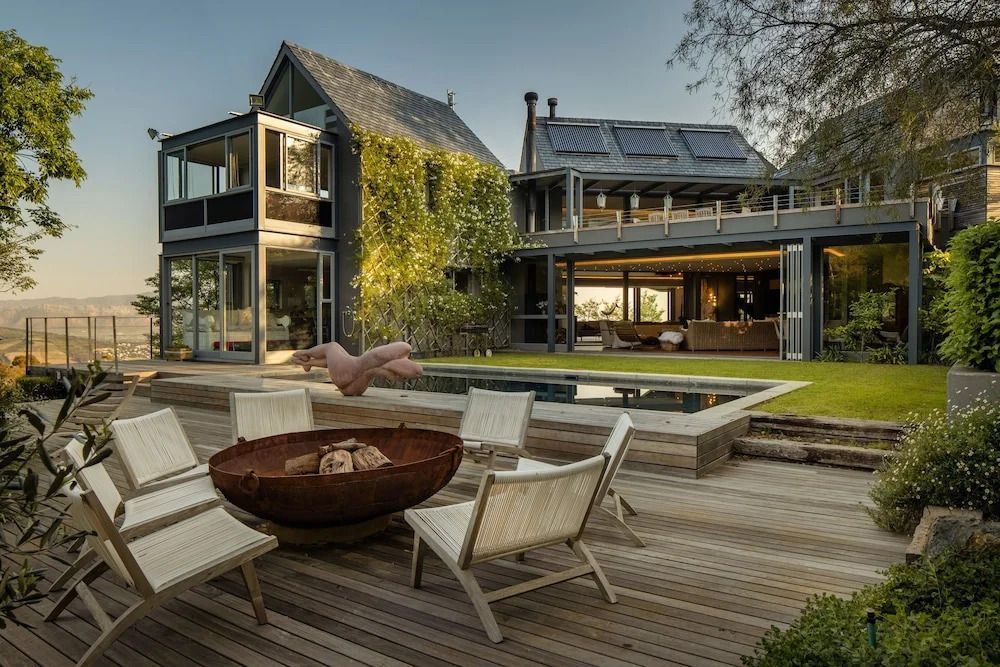 Außenbereich mit Holzterrasse und Pool vor einem eleganten Gebäude