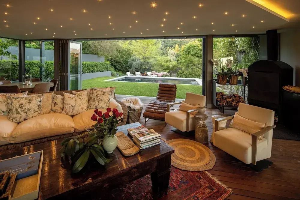 Luxuriöser Wohnbereich mit Zugang zum Garten und Blick auf den Pool.