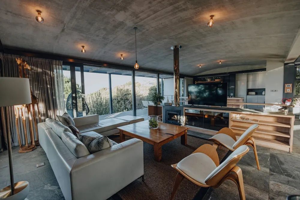 Helles Wohnzimmer der Villa mit großen Fenstern und stilvollen Möbeln.
