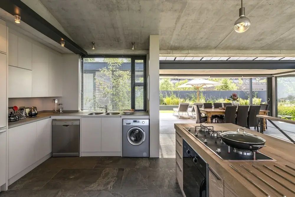 Moderne offene Küche mit Blick auf Wohnbereich und Terrasse.