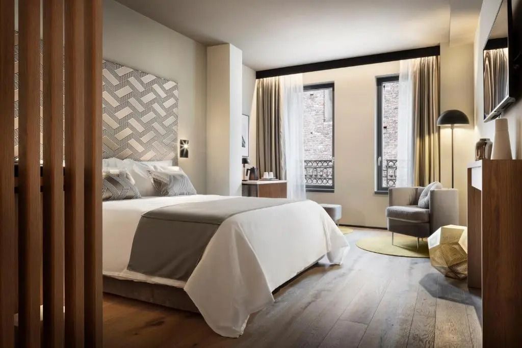 Deluxe Doppelzimmer mit modernem Design und großem Bett sowie Blick auf Fensterfront