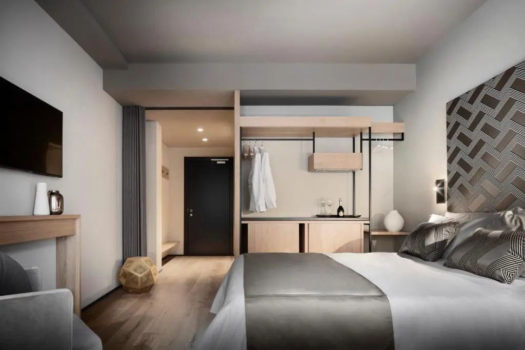 Modern eingerichtetes Deluxe Zimmer mit Blick auf Kleiderschrank und Lounge-Bereich