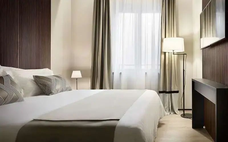 Helles Schlafzimmer mit Doppelbett und Vorhängen in der Doppel Junior-Suite