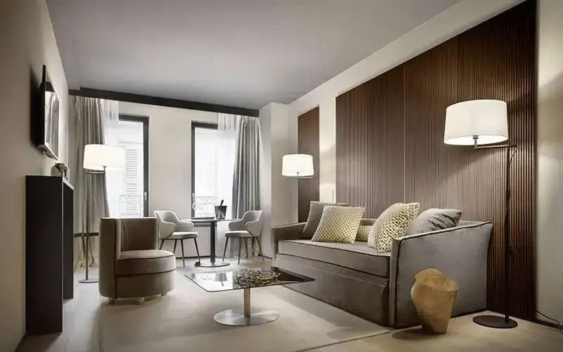 Großzügiger Wohnbereich der Suite mit grauem Sofa und stilvollen Details