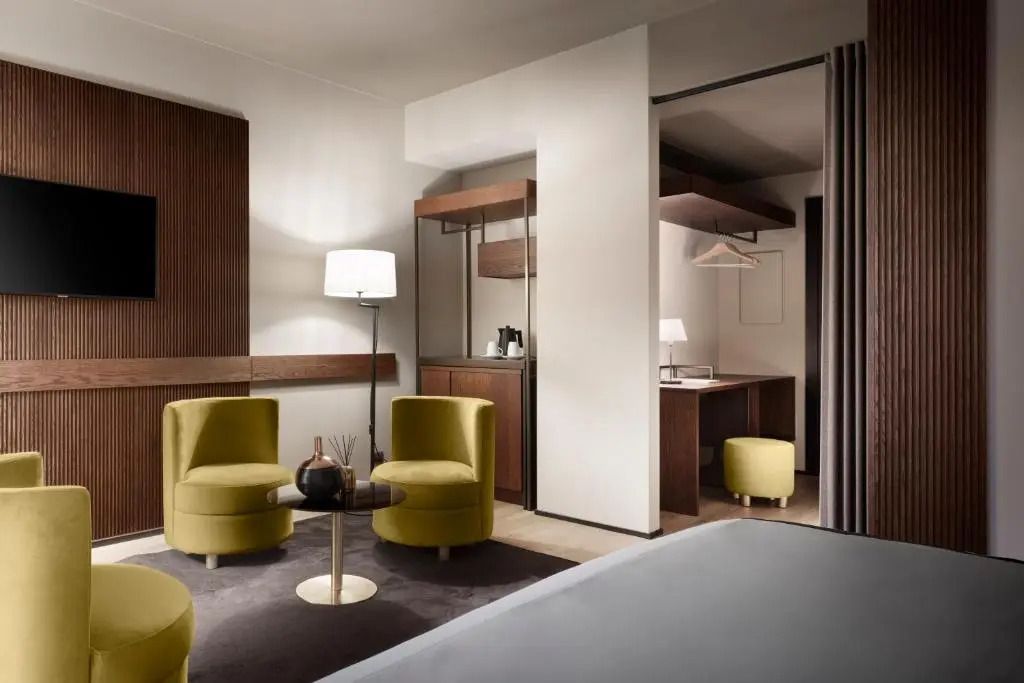 Moderner Hotelraum mit Sitzbereich, Schreibtischnische und warmem Licht