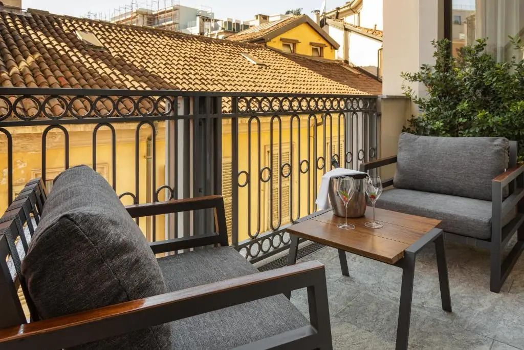Terrasse mit Blick auf Dächer Mailands, ausgestattet mit Stühlen und einem Tisch