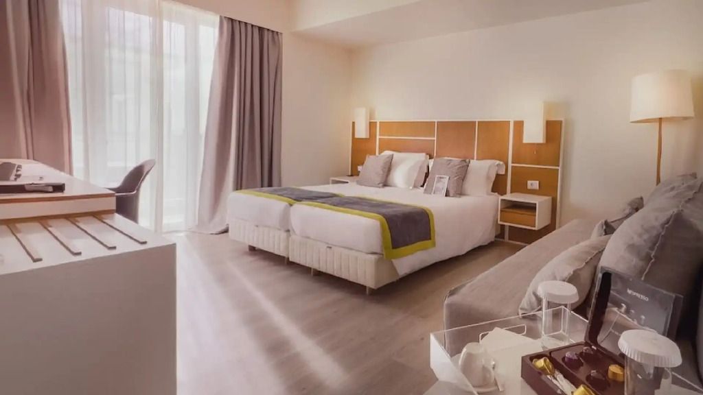 Helles Doppelzimmer mit zwei Einzelbetten, moderner Stil und bodentiefe Fenster
