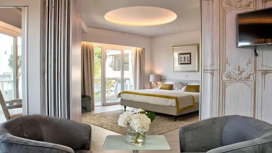 Geräumiges Familienzimmer mit großem Bett, eleganter Beleuchtung und Balkonzugang.