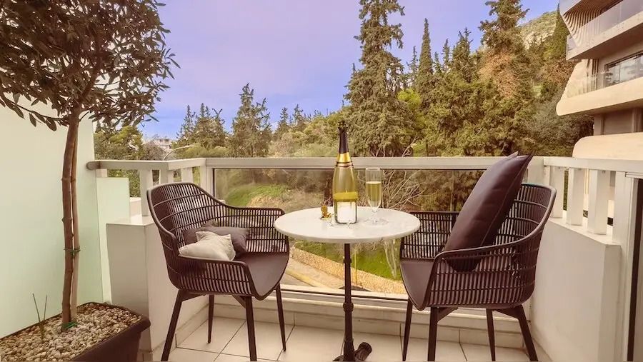 Balkon mit Sitzgelegenheiten und Blick auf grüne Umgebung, einladend zum Entspannen.