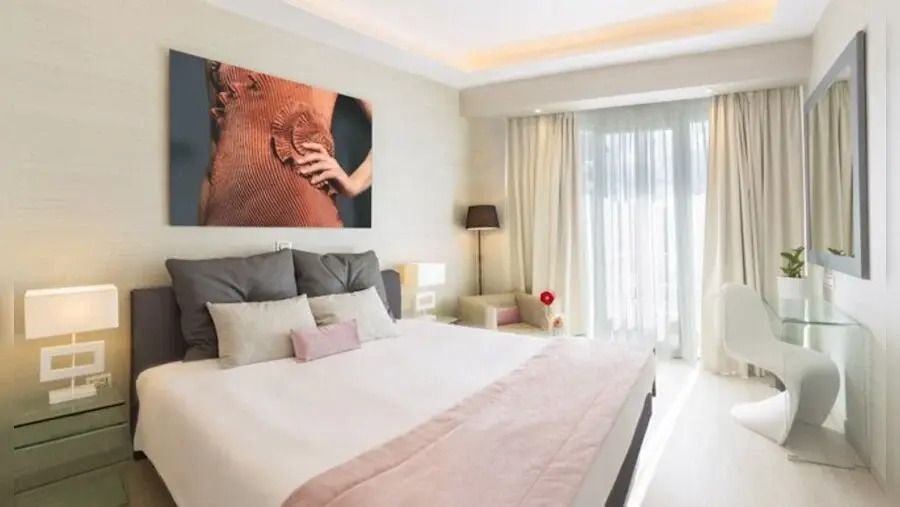 Elegantes Doppelzimmer mit stilvollem Kunstwerk und Balkonzugang