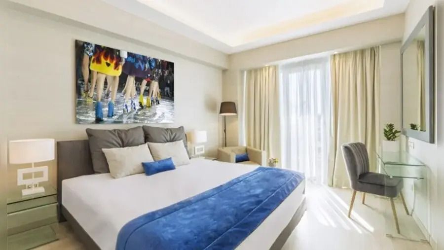 Modernes Doppelzimmer mit blauem Dekor und Zugang zu einem Balkon
