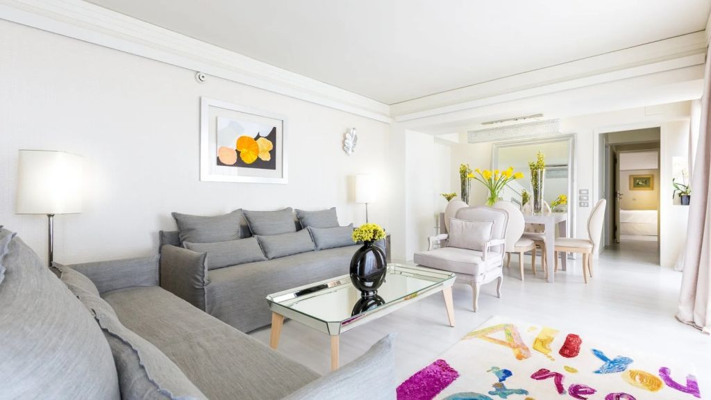 Helle und geräumige Suite mit stilvollen Möbeln und Kunstwerken an der Wand.