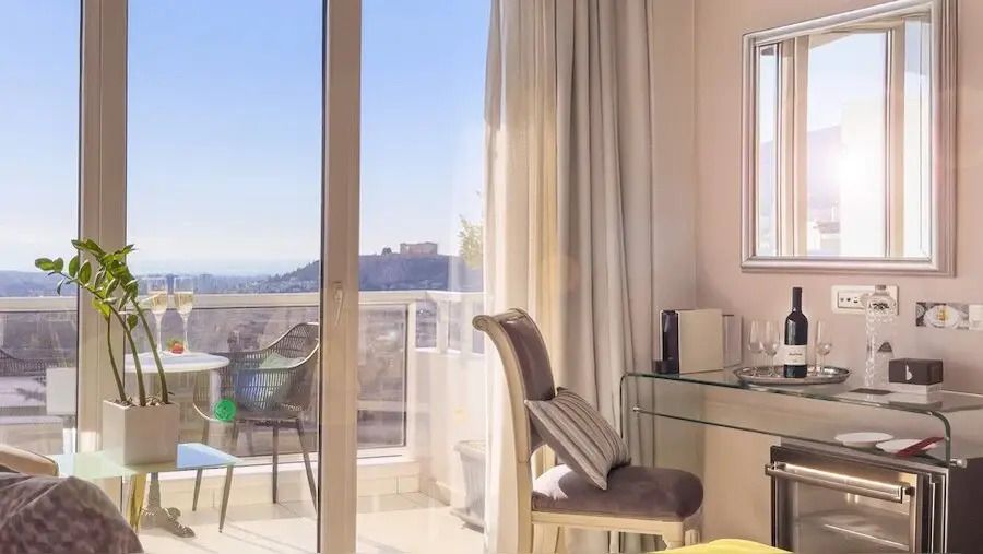 Eleganter Raum mit Balkon und Aussicht auf die Akropolis bei Sonnenlicht