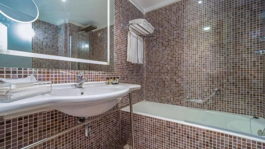 Modernes Badezimmer mit Mosaikfliesen und eleganter Einrichtung.