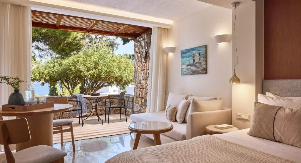Geräumiges Zimmer mit Sofaecke und Ausblick auf einen grünen Garten