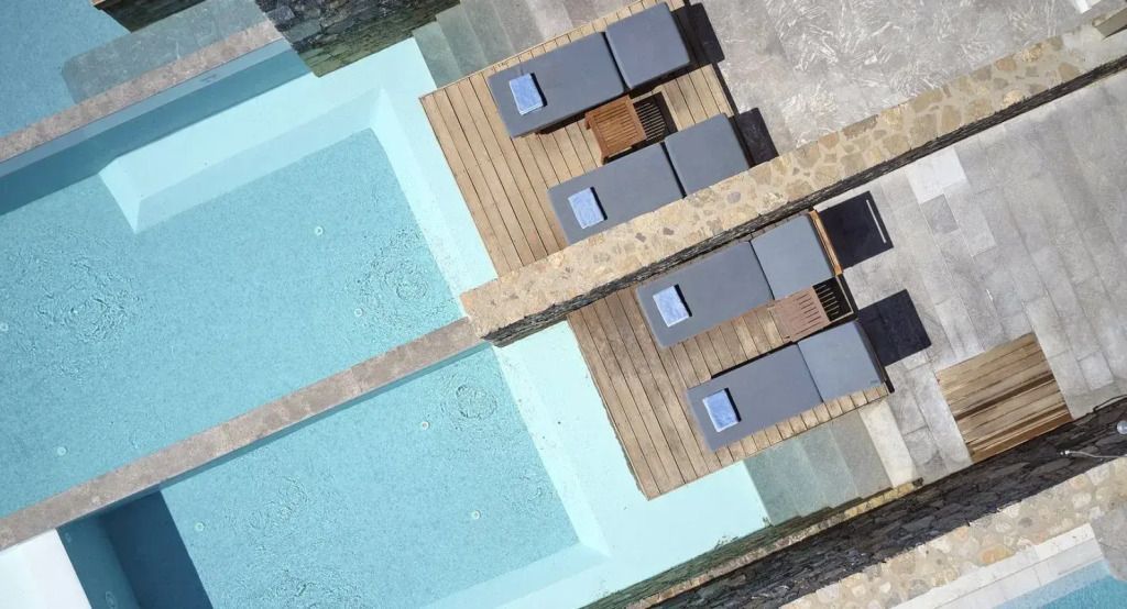 Luftaufnahme von Sonnenliegen und Pool in moderner Hotelanlage