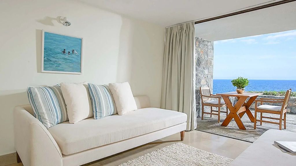 Helles Zimmer mit Sofa und Zugang zur Terrasse mit Meerblick