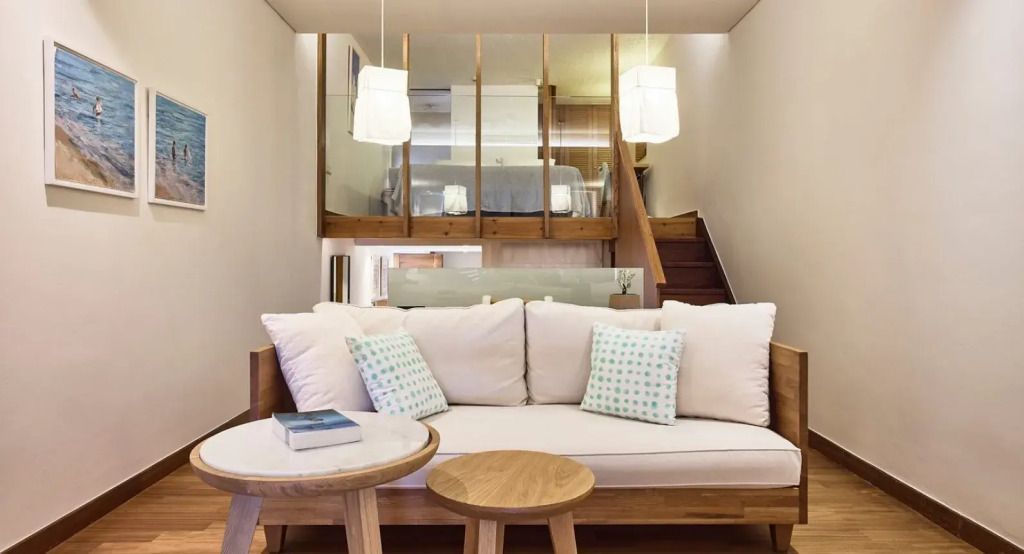 Einladendes Wohnzimmer mit Sofa und Treppe zur oberen Ebene in der Odysseas 1 Klub Suite.