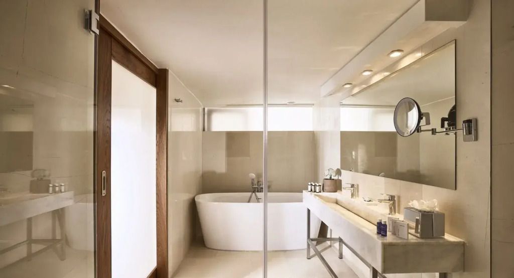 Luxuriöses Badezimmer mit Badewanne und großer Spiegelwand in der Odysseas 1 Klub Suite.