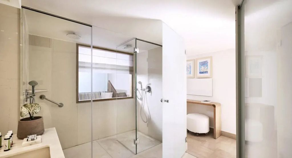 Geräumiges Badezimmer mit Glasdusche und stilvollem Waschbereich.