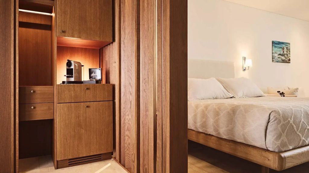 Holzverkleidung mit eingebauter Kaffeemaschine neben einem gemütlichen Schlafzimmer