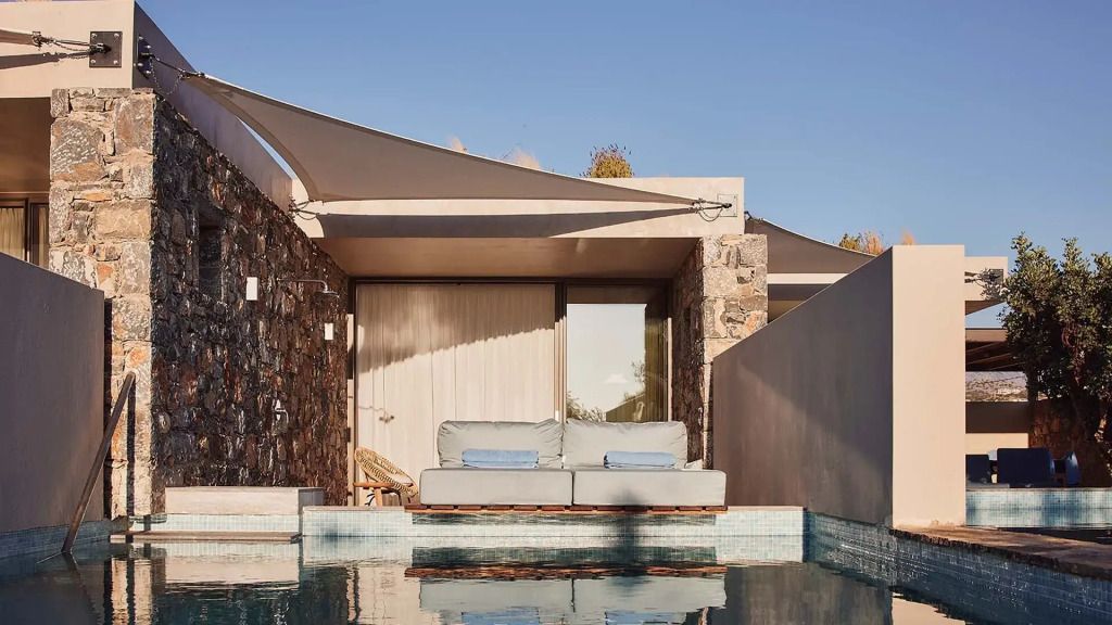 Private Terrasse mit Sofas vor einem kleinen Pool mit Steinelementen