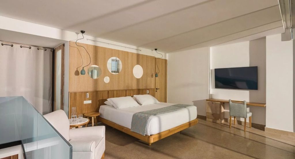 Modern gestaltetes Zimmer mit Doppelbett und stilvollen Hängelampen.