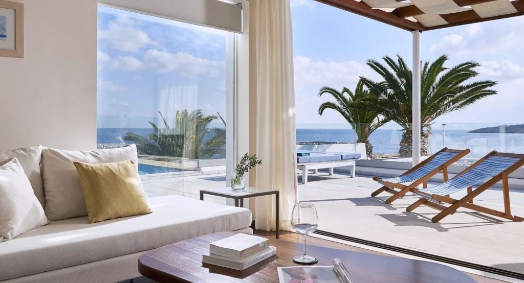 Moderne Suite mit Blick auf Pool und Meer, Glasfenster und Loungemöbeln
