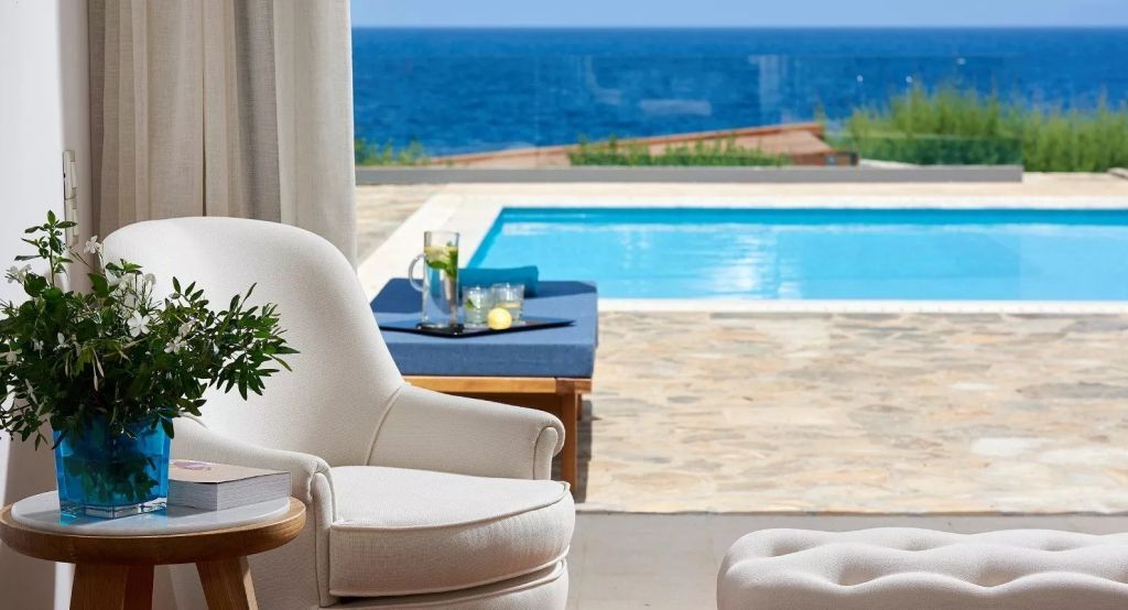Gemütlicher Sitzbereich mit Blick auf Pool und Meer, frische Dekorationen