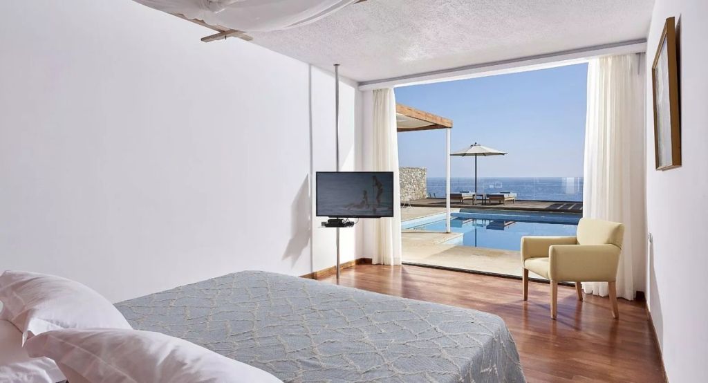 Helles Schlafzimmer mit Blick auf den privaten Pool und das Meer