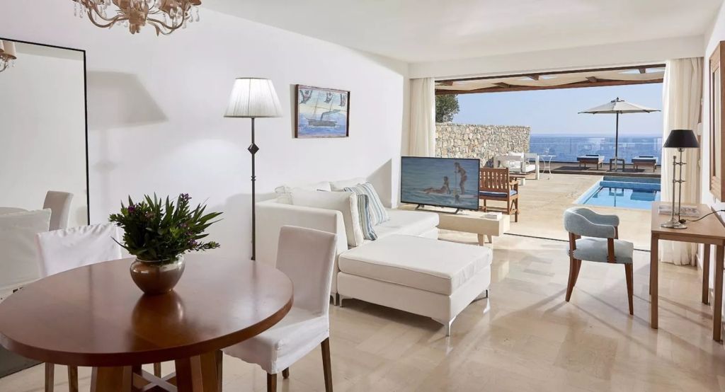 Wohnbereich mit weißer Sofa-Landschaft und Blick auf Terrasse und Meer