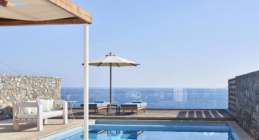 Privater Poolbereich mit Liegen und Parasols direkt am Meer