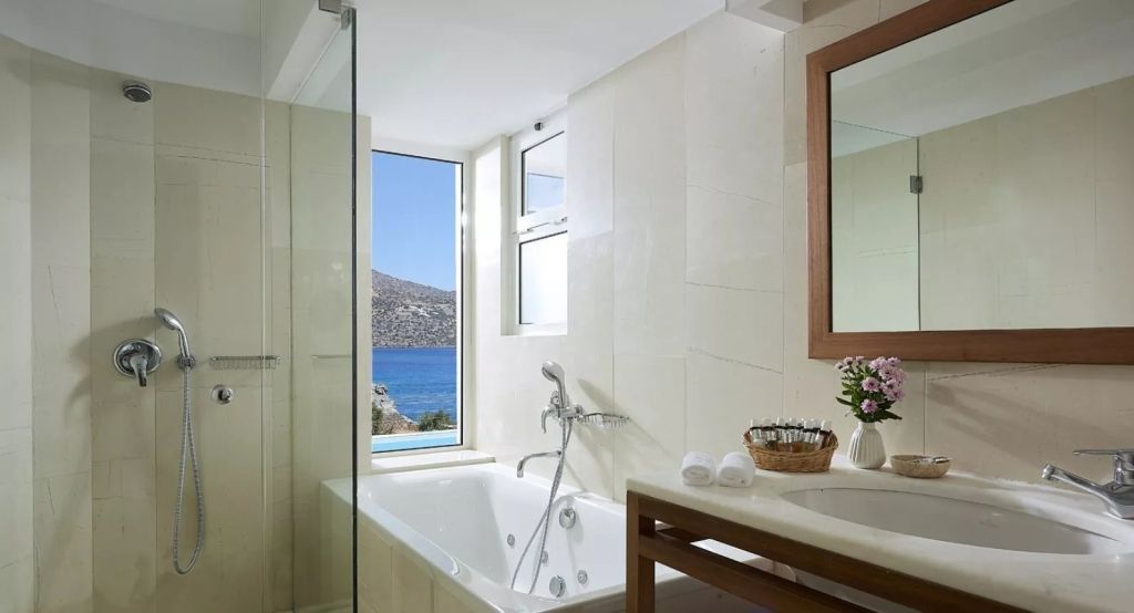 Modernes Badezimmer mit Whirlpool und Fensterblick aufs Meer