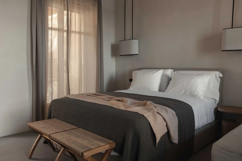 Gemütliches Schlafzimmer mit Doppelbett und eleganten Textilien im Stamna Sifnos Hotel.