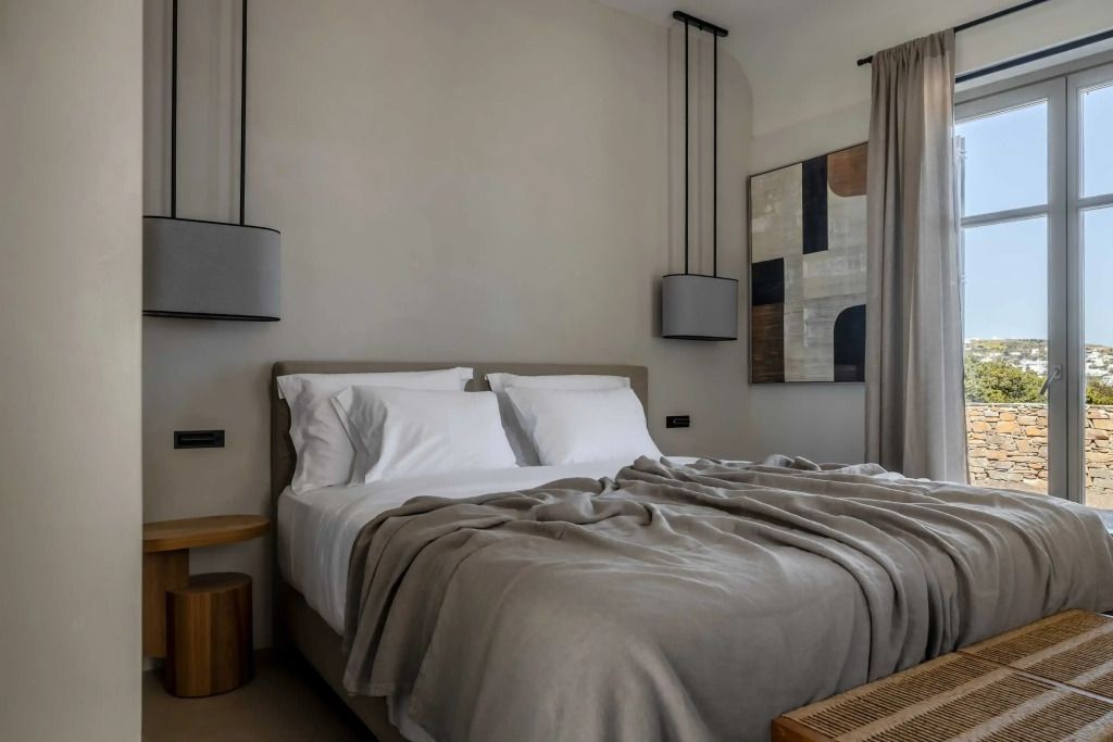 Gemütliches Doppelbettzimmer mit minimalistischer Einrichtung und Kunstwerken an der Wand