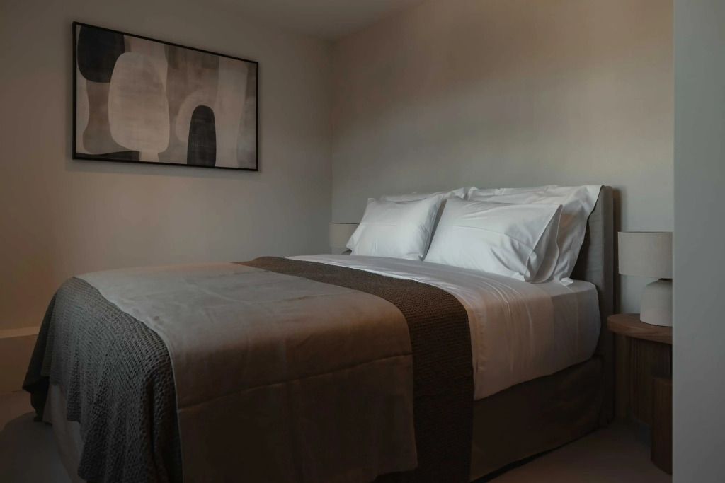 Gemütliches Doppelbett in einem stilvoll beleuchteten Hotelzimmer