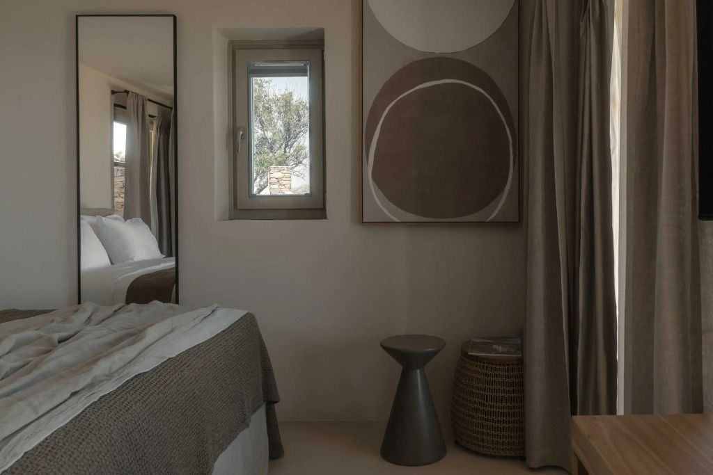 Helles Hotelzimmer mit dekorativem Fenster und moderner Kunst