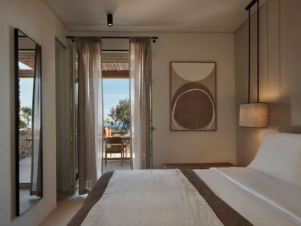 Suite mit Bett, Kunst an der Wand und Blick nach draußen.