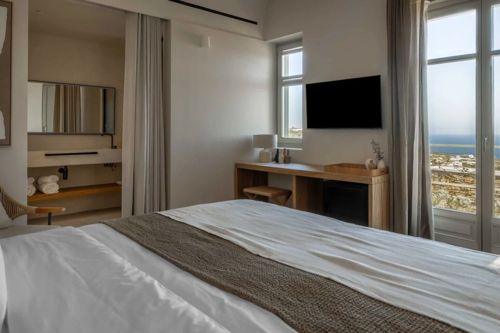 Elegantes Superior Zimmer mit einem gemütlichen Bett und Meerblick vom Fenster.