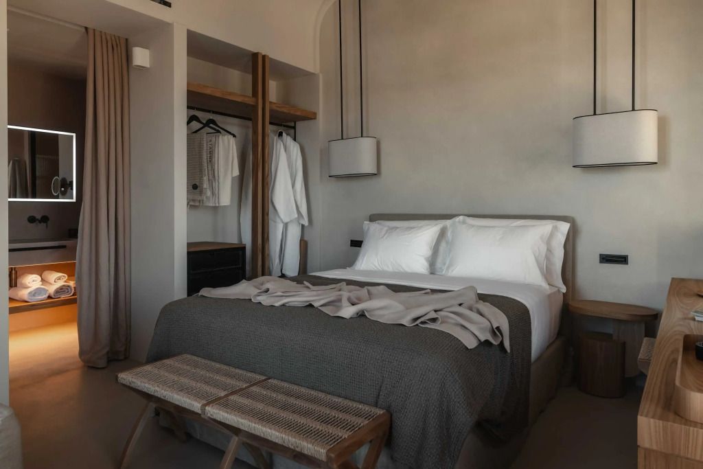 Superior Zimmer mit einladendem Bett, offener Garderobe und dezenter Beleuchtung.