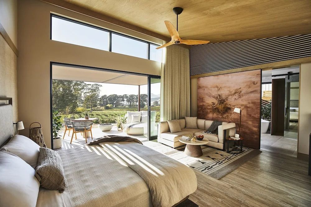 Großzügiges Zimmer mit Doppelbett und Sitzbereich sowie Blick auf grüne Landschaft