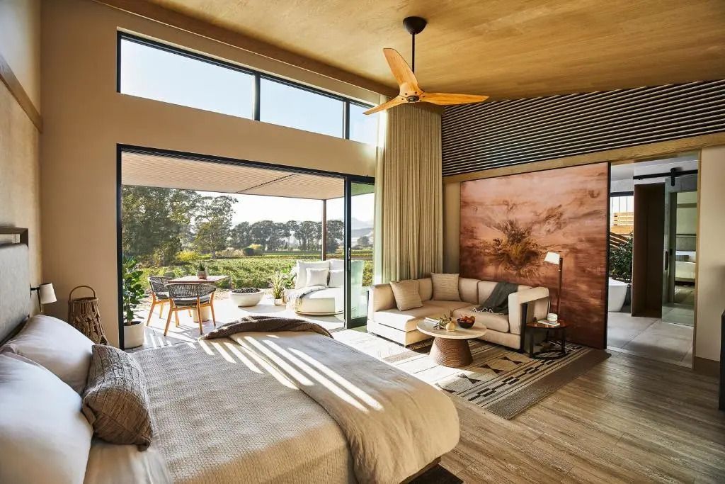 Geräumiges Hotelzimmer mit Doppelbett und großem Fenster mit Blick ins Grüne