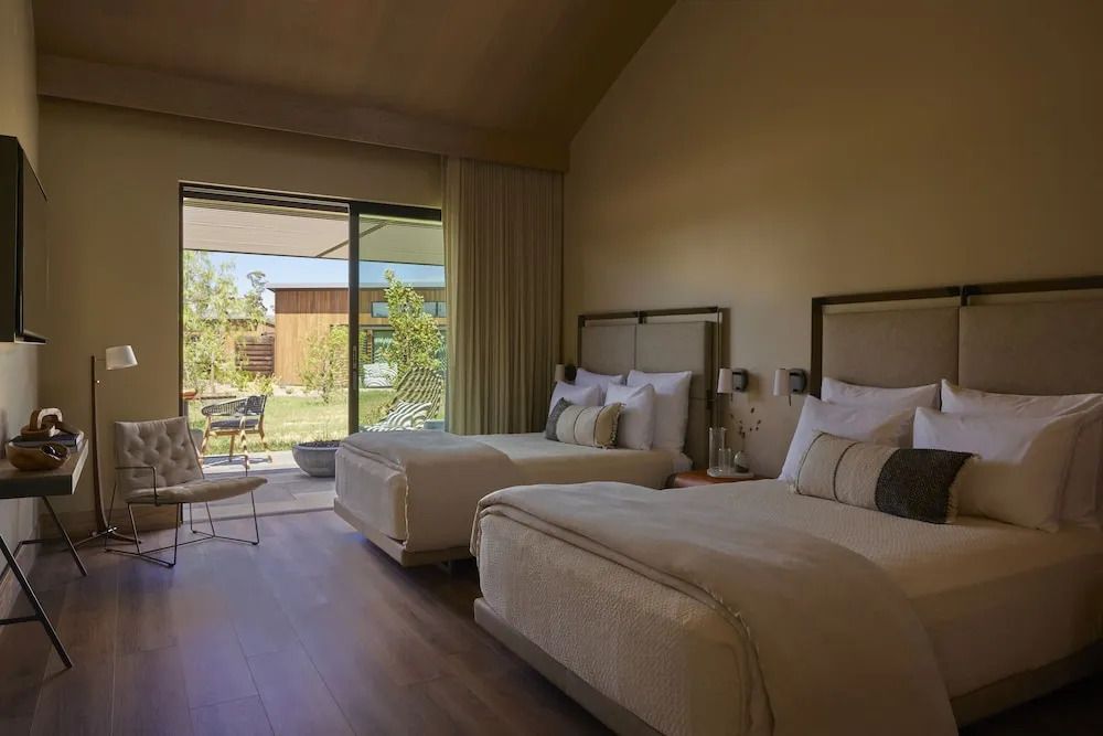 Elegant eingerichtetes Hotelzimmer mit zwei Doppelbetten und Terrasse